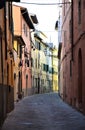 Beautiful and typical street, with the facades of the most distant buildings illuminated by the setting sun, in the center of Pist