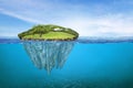 Beautiful underwater view of lone small island above and below the water surface in turquoise waters of tropical ocean Royalty Free Stock Photo