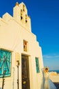 Model posing in white bridal dress in front of old chapel Santorini island Greece