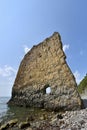 A beautiful and unusual rock in the sea, vertical, flat and high, next to a rocky shore. Her name Sail in Russian Royalty Free Stock Photo