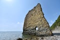 A beautiful and unusual rock in the sea, vertical, flat and high, next to a rocky shore. Her name Sail in Russian Royalty Free Stock Photo