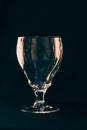 A glass on a black background, an olive drops in a glass with splashes