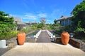 Beautiful upscale resort hotel with small wooden bridge entrance connecting to the villas with two big pots Royalty Free Stock Photo