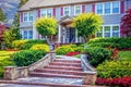 Beautiful upscale two story detached home with red shutters and curving sidewalk leading up from spreading rock steps landscaped