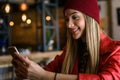 Smiling beautiful urban girl using smart-phone out in the cafeteria