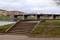 Beautiful urban landscape with view of big stone bridge over river and embankment with old buildings, architecture of small town.