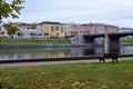 Beautiful urban landscape with view of embankment with old buildings, river and bridge. Architecture of small town.