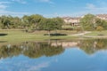 Beautiful urban park with lake reflection and apartment complex in background near Dallas