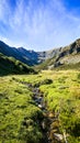 Impresive mountain scenary with a stream and beautiful colors with an amazing blue sky Royalty Free Stock Photo