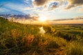 A beautiful valley with a river, blue sky with large clouds and bright sun. Aerial Royalty Free Stock Photo