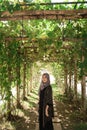 Beautiful veiled woman standing under a creeping tree Royalty Free Stock Photo