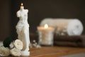 Beautiful Venus De Milo candle and white roses on wooden table in room, space for text Royalty Free Stock Photo