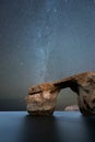 A beautiful vertical Milky Way night sky landscape photograph of the famous Azure Window rock arch