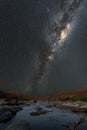 A vertical night sky landscape with the Milky Way and a river