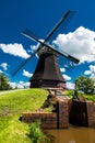 Beautiful vertical shot of a black windmill on a hill with a cloudy sky background Royalty Free Stock Photo