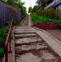 Beautiful vertical shot of old staircases surrounded by green grass and trees near a building Royalty Free Stock Photo