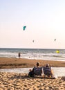 Beautiful vertical shot of people relaxing at the beach at soft sunset Royalty Free Stock Photo