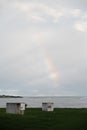 Beautiful vertical shot of a rainbow covered by gray clouds over the sea at Kiama, Australia