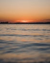 Beautiful vertical view of sea water under the clear sky during sunrise Royalty Free Stock Photo