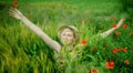 Beautiful very happy blonde woman with arms outstretched in a wheat field in summer sun`s rays. Horizontal image Royalty Free Stock Photo
