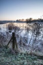 Beautiful vibrant English countryside lake image with frost and Royalty Free Stock Photo