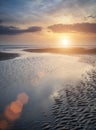 Beautiful vibrant Summer sunset over golden beach landscape with