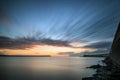 Beautiful vibrant sunrise sky over calm water ocean with lighthouse and harbor wall Royalty Free Stock Photo