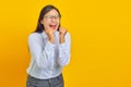 Beautiful and vibrant young business woman celebrating success with raised hands on yellow background Royalty Free Stock Photo