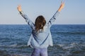 Beautiful victorious teenager in front of the mediterranean sea with arms raised