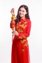 Beautiful Vietnamese woman with red ao dai holding lucky new year ornament - stack of gold Royalty Free Stock Photo