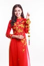 Beautiful Vietnamese woman with red ao dai holding lucky new year ornament Royalty Free Stock Photo