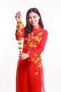 Beautiful Vietnamese woman with red ao dai holding lucky new year ornament Royalty Free Stock Photo