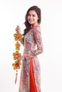 Beautiful Vietnamese woman wearing impression ao dai holding lucky decorate object Royalty Free Stock Photo