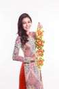 Beautiful Vietnamese woman wearing impression ao dai holding lucky decorate object Royalty Free Stock Photo