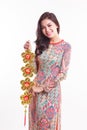 Beautiful Vietnamese woman wearing impression ao dai holding lucky decorate object Royalty Free Stock Photo
