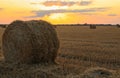 Beautiful view of agricultural field with hay bales at sunset Royalty Free Stock Photo