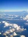 A beautiful view from an airplane on white voluminous fluffy clouds against the background of a bright blue sky Royalty Free Stock Photo