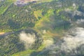 Beautiful view from airplane window looking down on green forest areas and fields with some clouds. Countryside rural area with Royalty Free Stock Photo