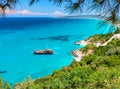 Beautiful view on amazing island bay with pirate corsair style boat ship, swimming people, beach in Ionian Sea blue water, Greece