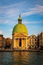 Beautiful view of an architectual building with a bronze dome and other buildings along the water