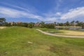 Beautiful view of Aruba`s hotel golf course. Green grass and pink buildings behind Green trees on blue sky Royalty Free Stock Photo