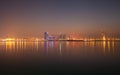 Illuminated Bahrain skyline with mist during sunset