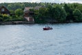 Ivanovo region, Russia, July 3, 2023. A small boat with people on the river against the backdrop of the village.