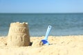 Beautiful view of beach with sand figure and shovel near sea Royalty Free Stock Photo