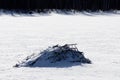 A beautiful view of a beaver dam covered in snow on a lake on cold winter day in Elk Island National Park
