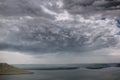 Beautiful view on big lake among hills and rain from clouds. River and cliffs landscape. Bakota lake and Dnister river in Ukraine