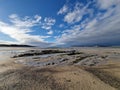 Beautiful view of the blue sky with floating clouds above mudflats on a bright day Royalty Free Stock Photo