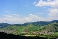 A beautiful view of the blue sky, white clouds, green hills, villages, winding roads