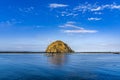 Beautiful view of a boat near an island in the middle of the ocean under the blue sky Royalty Free Stock Photo