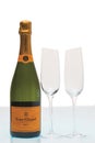 Beautiful view of bottle of champagne Veuve Clicquot and two slim, tall and elegant champagne glasses.
